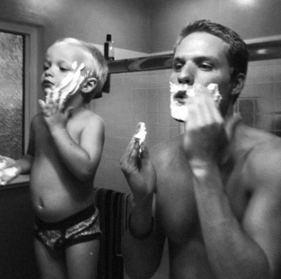 Black and white photo of father and young child shaving together — MN8 Father's Day gift guide