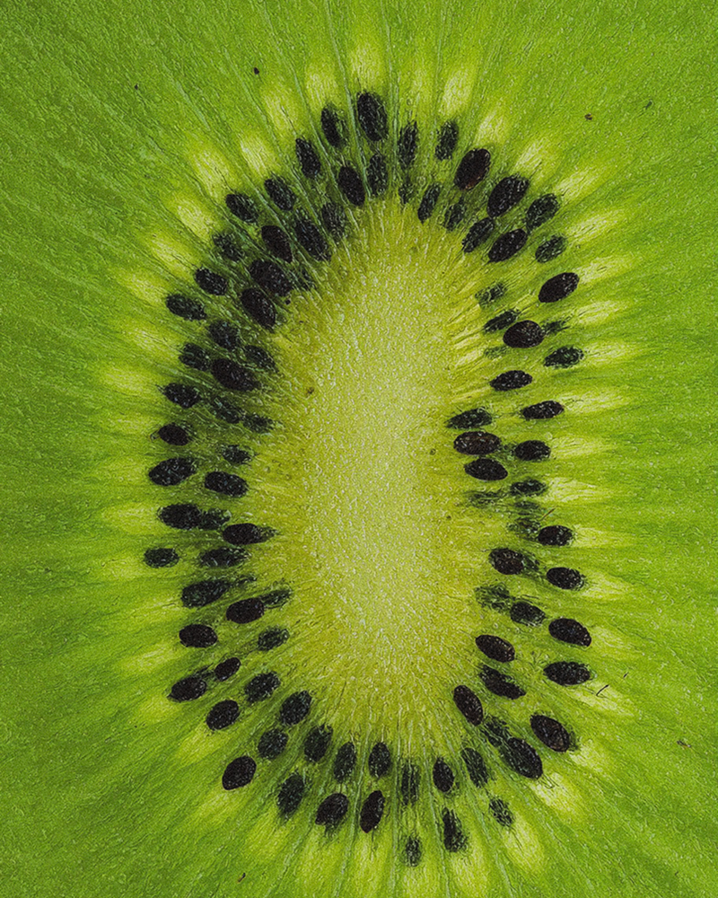Cross-section of a fresh kiwifruit showing seeds and green flesh — kiwifruit extract ingredient